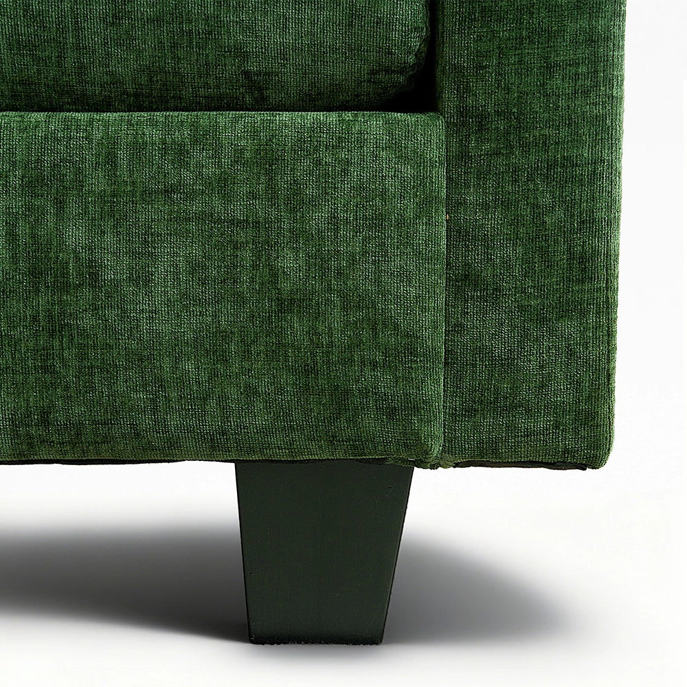 Close-up of a green upholstered chair corner on a white background