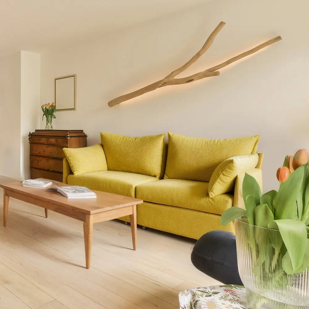 Organic modern interior design featuring the sunlit yellow Huddle sofa surrounded by indoor plants and natural light.
