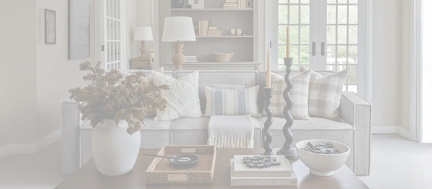 ABCASA light gray tofu modular sofa in a cozy, neutral-toned living room with a dark wood coffee table, French doors, soft textiles, and warm decorative accents.